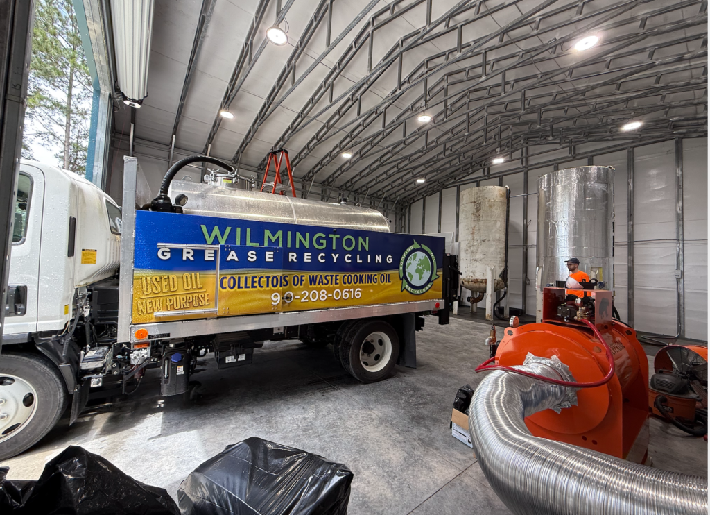 Wilmington Grease Recycling truck inside a recycling facility with industrial used cooking oil processing equipment.
